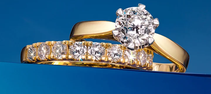 Złoty pierścionek z dużym okrągłym diamentem w 6 łapkach i złota obrączka z szeregiem diamentów